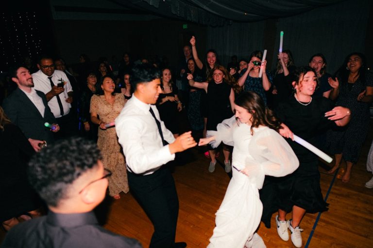 Guests dancing with glow sticks at a reception with Total DJs