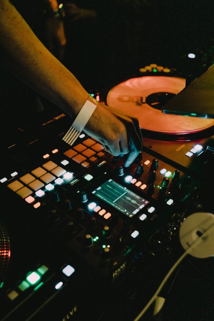 Close-up of a DJs hand on a mixer, adjusting controls during a live performance.