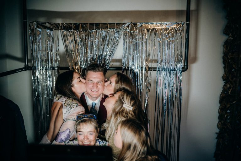 Guests laughing together in the photo booth at a Total DJs party