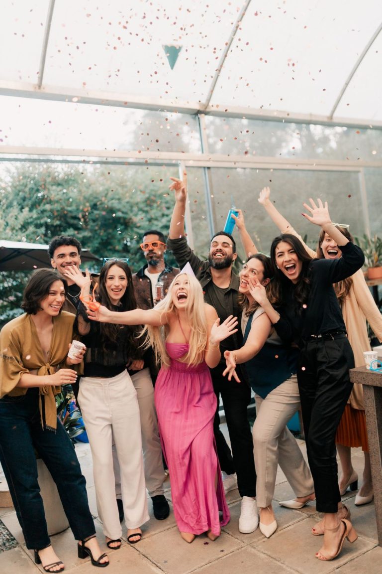 Friends cheering under falling confetti at a party