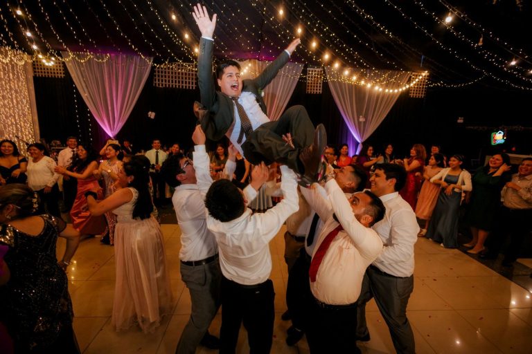 Wedding guests lifting the groom on a packed dance floor